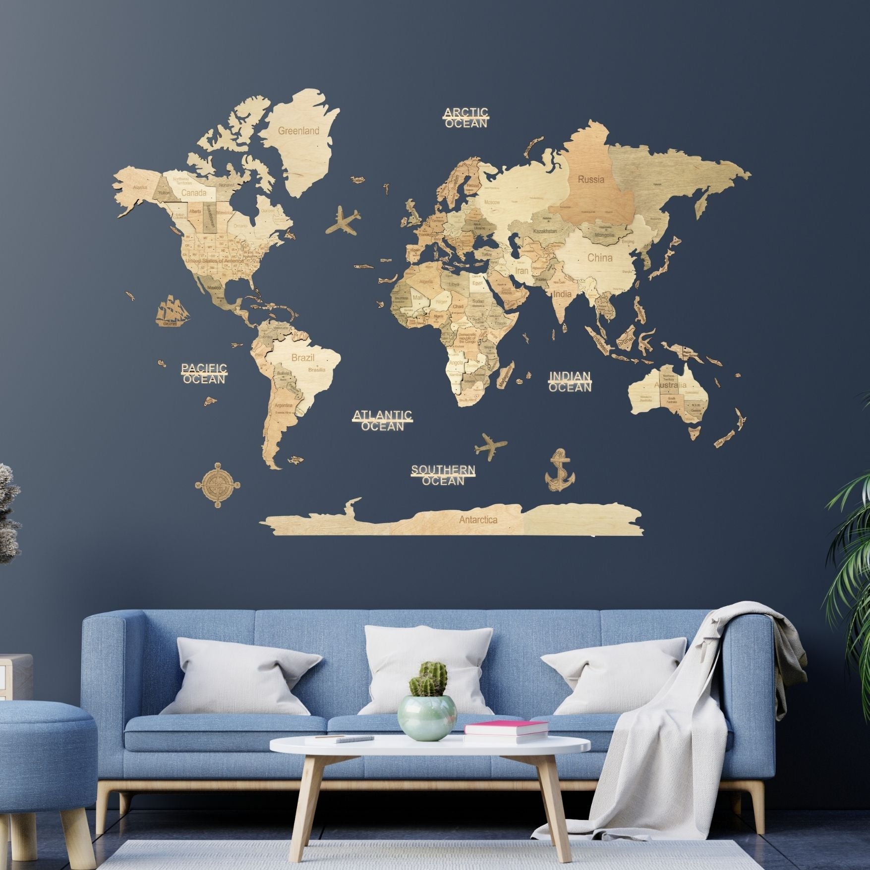World map wall decal on a dark blue wall with a blue sofa and coffee table in a living room #Map language_English