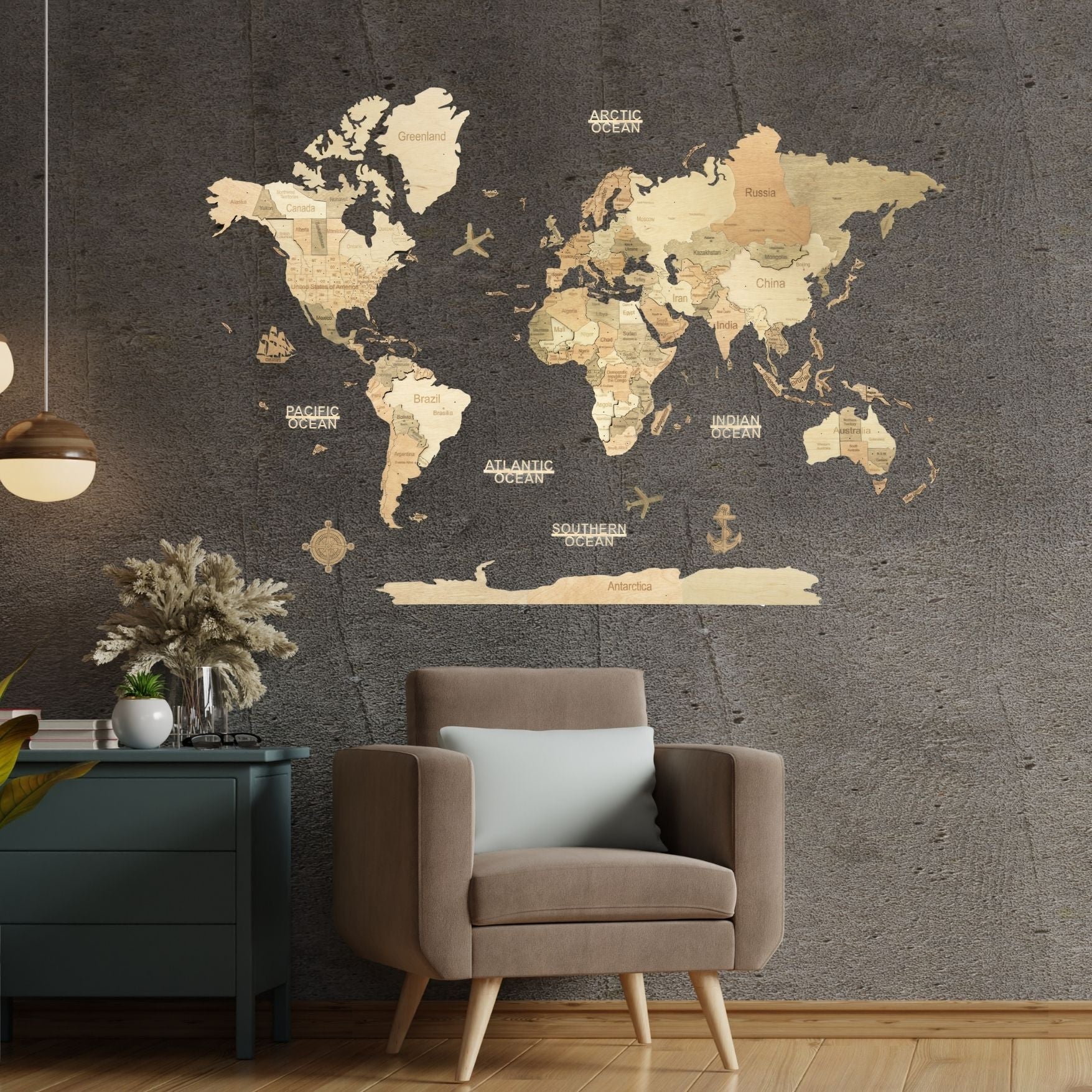 A large vintage-style world map wall decal with gold and beige continents is displayed on a dark textured wall above a brown armchair in a modern living room setting #Map language_English