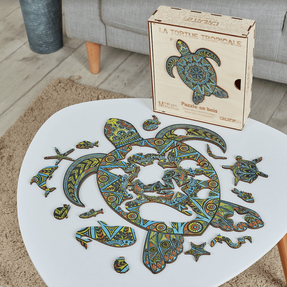 Colorful turtle-shaped wooden puzzle with packaging on a white table