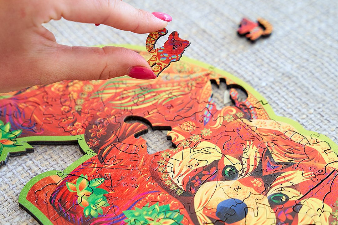 A nearly finished Red Panda wooden puzzle on a blanket, two pieces still to place